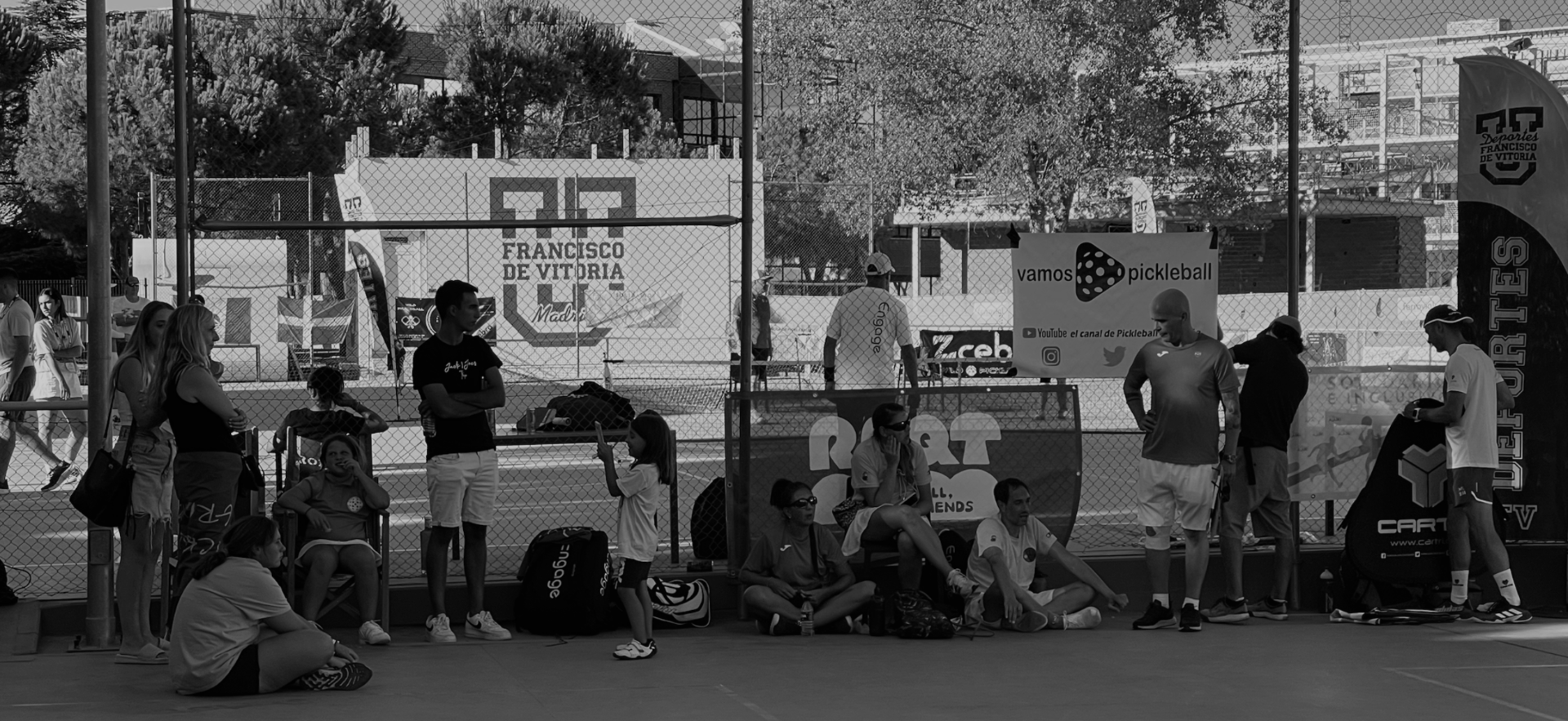 Pickleball tournament with players resting courtside